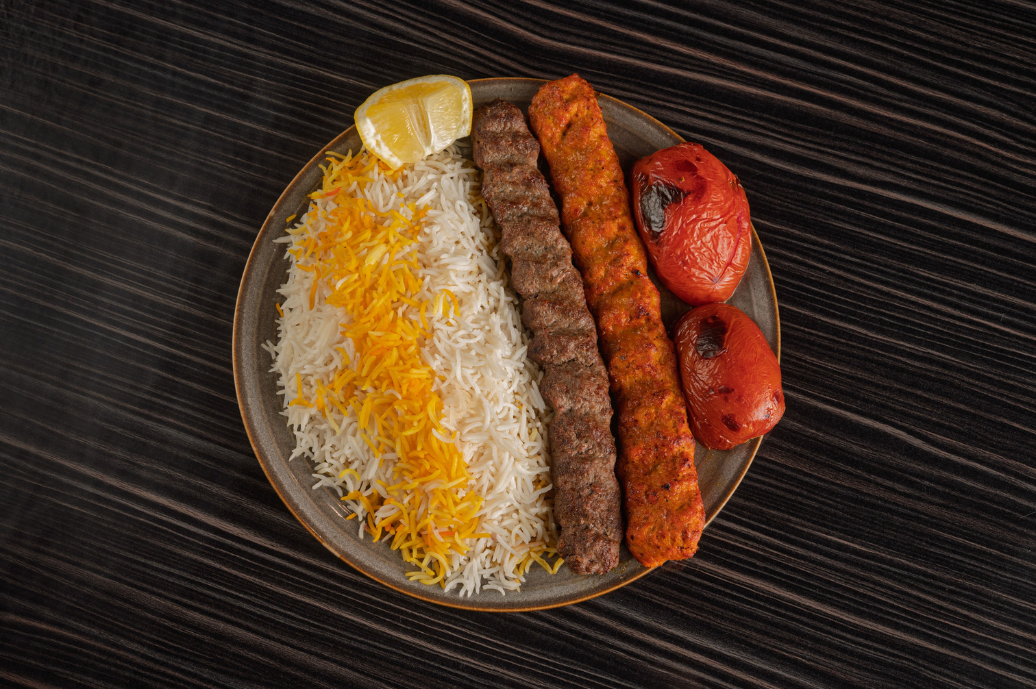 Authentic Persian Beef Koobideh served with saffron basmati rice and grilled tomato in Houston restaurant